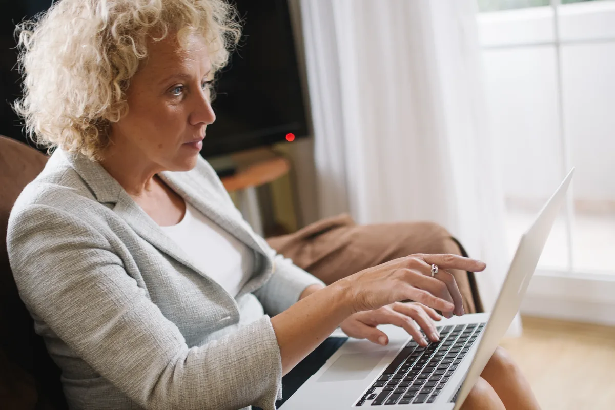 An older adult examining and pointing at a laptop screen